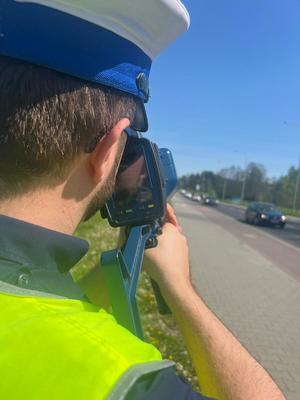 Na zdjęciu policjant ruchu drogowego mierzący prędkość
