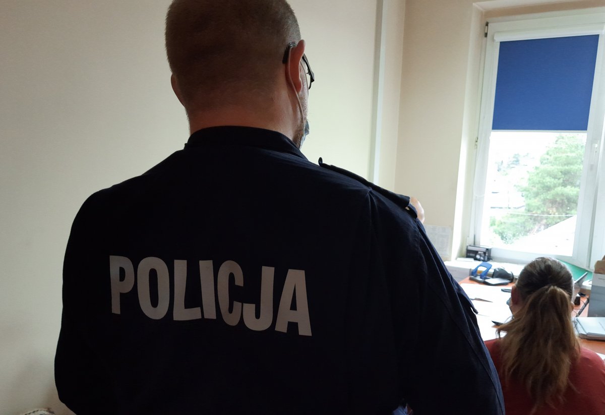 Policjant i kobieta w pomieszczeniu służbowym 