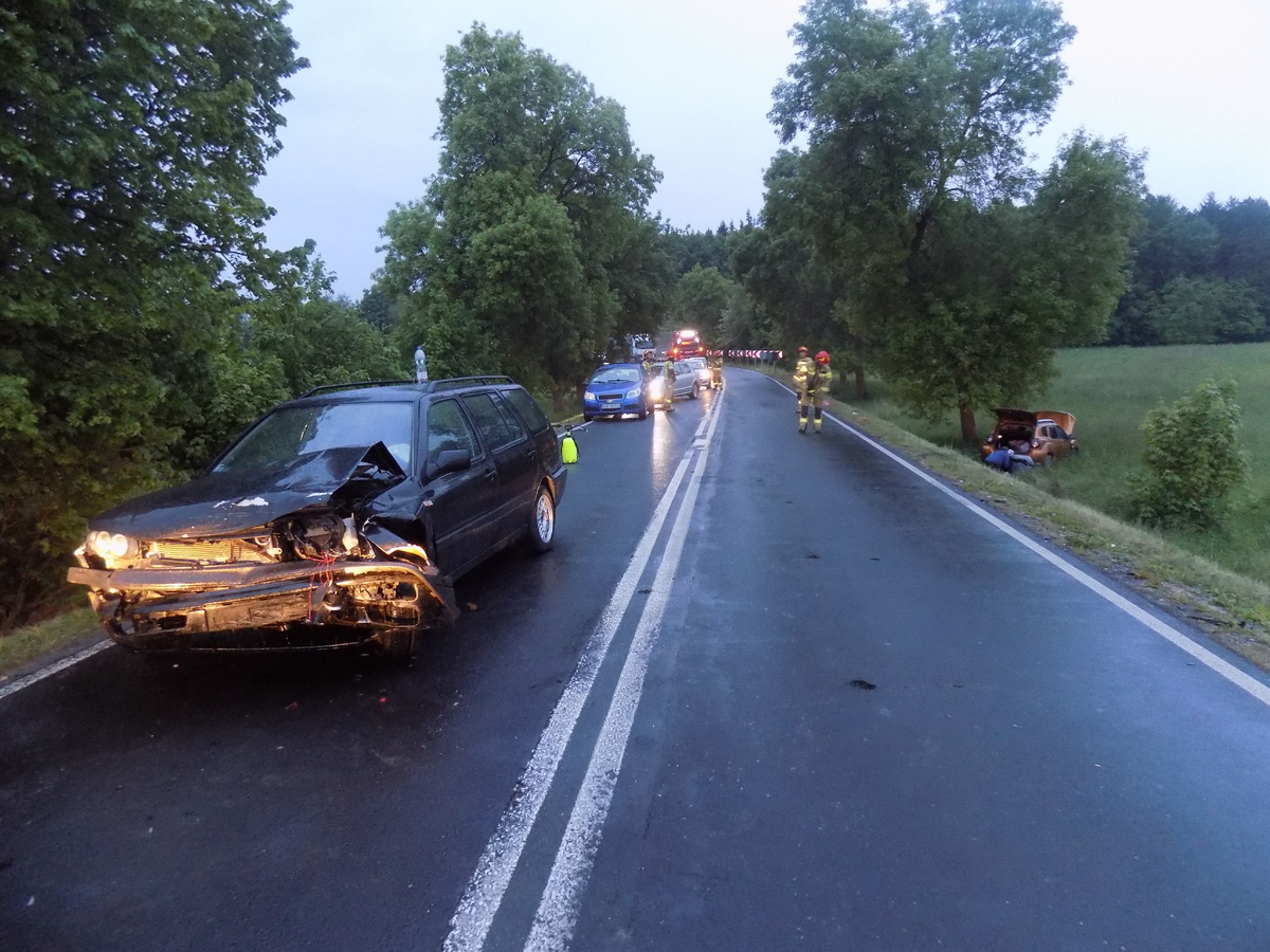 Uszkodzony pojazd stoi na drodze, drugi z uczestniczących w zdarzeniu leży w przydrożnym rowie