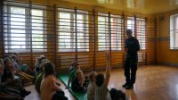 Policjantka prowadzi prelekcję z dziećmi w szkole