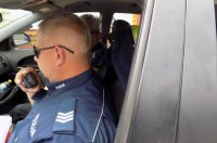 Policjant prowadzi korespondencję z dyżurnym jednostki drogą radiową