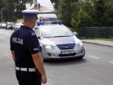 Policjant na drodze przy radiowozie