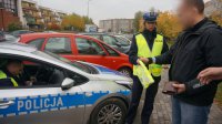 Policjantka wręcza opaskę odblaskową