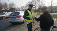 Policjant wręcza element odblaskowy