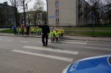 Policjant przeprowadza dzieci przez jezdnię