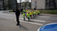 Policjant i dzieci przechodzą przez przejście dla pieszych