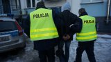 Policjanci doprowadzają zatrzymanego