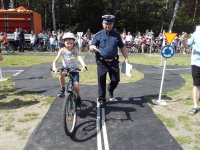 Policjant egzaminuje ucznia zdającego egzamin praktyczny na kartę rowerową