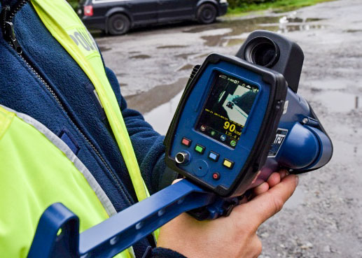 Laserowy miernik prędkości w rekach policjanta