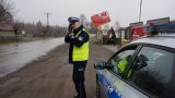 Policjant mierzy prędkość pojazdów na drodze