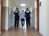 Policjanci doprowadzają zatrzymanego