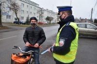 Policjant wręcza odblask rowerzyście