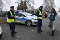 Policjant wręcza odblask pieszej