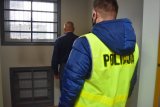 Policjant pilnuje zatrzymanego w pokoju z kratami