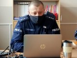 Policjant w maseczce przed komputerem