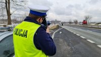 Policjant mierzy prędkość pojazdów na drodze