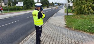 Policjant na drodze mierzy prędkość pojazdów