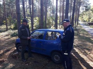 Patrol kontroluje auto zaparkowane w lesie