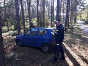 Patrol kontroluje samochód zaparkowany w lesie