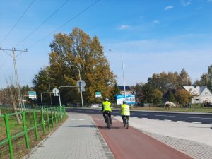 Rowerzyści odjeżdżąją w kaskach i kamizelkach odblaskowych