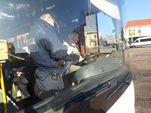 Policjant rozmawia wewnątrz autokaru z kierowcą