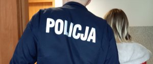 Policjant doprowadza zatrzymaną