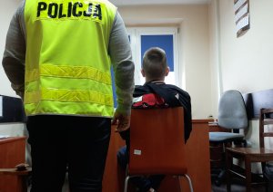 Policjant pilnuje zatrzymanego w pokoju służbowym