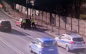 Policjanci spychają samochód z ruchliwej drogi