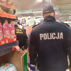 Policjant i strażnik kontrolują sklep wielkopowierzchniowy