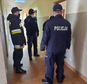 policjanci i strażacy sprawdzają wnętrza budynku