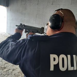 Policjant strzela z długiej broni