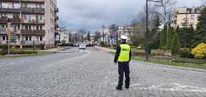 Policjant zabezpiecza drogę przemieszczania się wiernych ulicą miasta