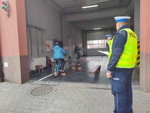 Uczestnik pod okiem policjanta rowerem pokonuje tor przeszkód