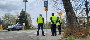 Policjant i strażnicy miejscy nadzorują przejście dla pieszych