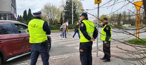 Policjant i strażnicy miejscy nadzorują rejon przejścia dla pieszych