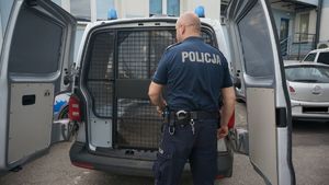 Zatrzymany siedzi w policyjnym radiowozie-obok pilnuje go policjant