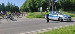 Policjant zabezpiecza przejazd kolarzy