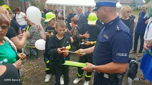 Policjant wręcza dzieciom odblaski