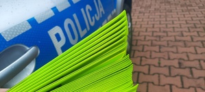 Opaski odblaskowe trzymane przy napisie Policja