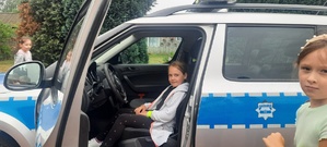 Dziewczynka siedzi w policyjnym radiowozie