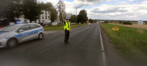 Policjant zabezpiecza trasę przejazdu motocyklistów