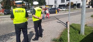 Policyjny patrol stoi przy przejściu dla pieszczych