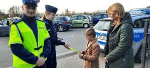 Policjantka wręcza opaskę odblaskową chłopcu