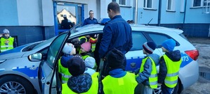 Policjant z dziećmi zwiedzają radiowóz