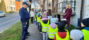 Policjanci żegnają się z dziećmi stojąc przy drodze