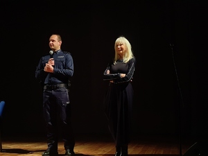 Policjant i kobieta stoją na scenie