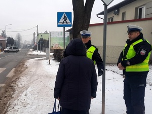 Patrol policji rozmawia przy przejściu dla pieszych z kobietą