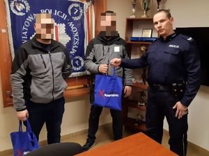 Policjant wręcza upominek jednemu ze świadków