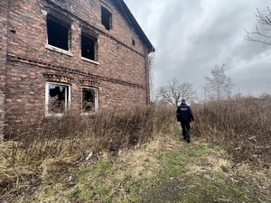 Na zdjęciu policjant idący do pustostanu