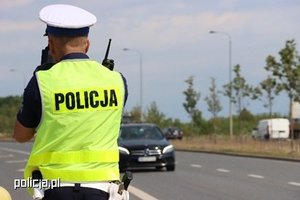 Na zdjęciu policjant ruchu drogowego w odblaskowej kamizelce z napisem policja